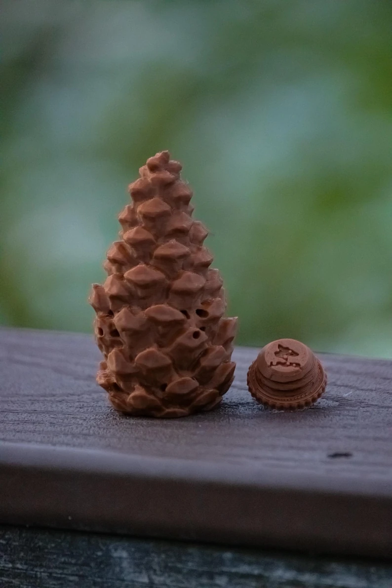 Pinecone-shaped scent hide beside its removable threaded base